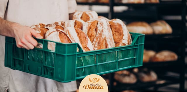 Padeiro carregando caixa de pães frescos